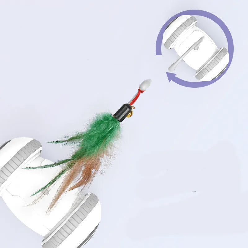 White and grey automatic interactive cat toy with interchangeable feather accessory on a floor, USB cable attached