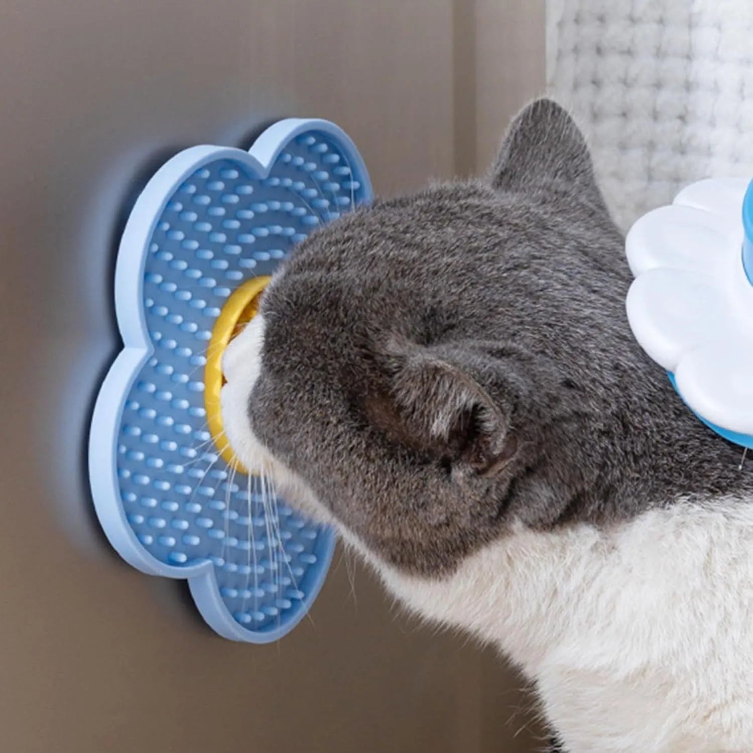 A blue flower-shaped silicone lick mat for pets with four white suction cups on the underside.