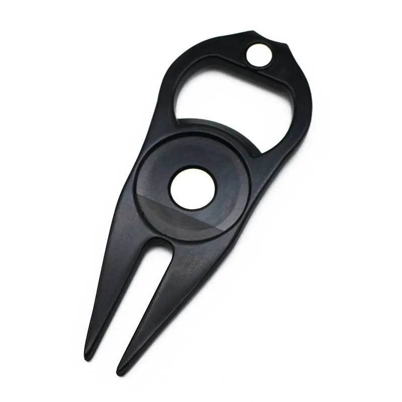 Black zinc alloy golf ball yoke fork with integrated bottle opener tool on green turf.