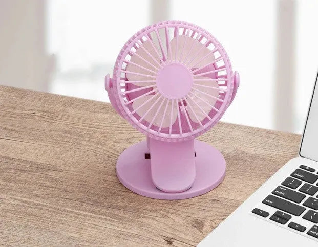 Small white clip fan with plastic blades attached to a surface, showing USB cable and piano button switch.