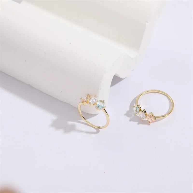 Geometric triangle ring with tricolour zircon stones in horse eye pattern and gold colour finish