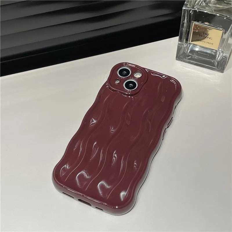 Silicone mobile phone case for iPhone 17 with a solid green colour and water ripple texture on a flat surface.