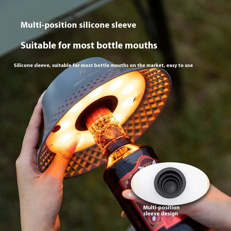 Beige wine bottle camping lantern with USB-C charging port and adjustable light modes on a wooden surface.
