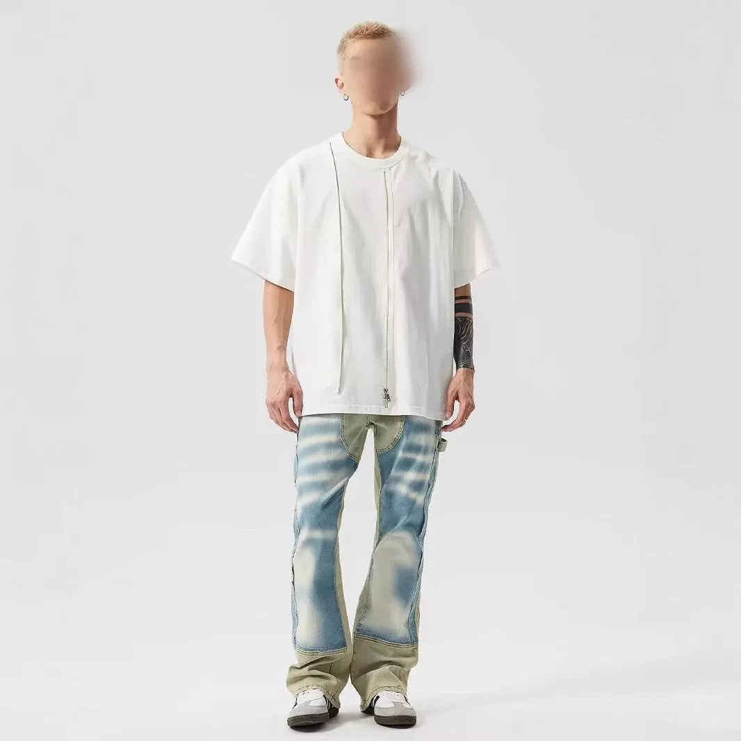 Yellow and blue retro patchwork jeans with splash-ink distressed detailing, showing mid waist and zip fly.