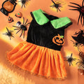 Small dog wearing a orange crystal velvet Halloween pumpkin skirt costume with green leaf accents.