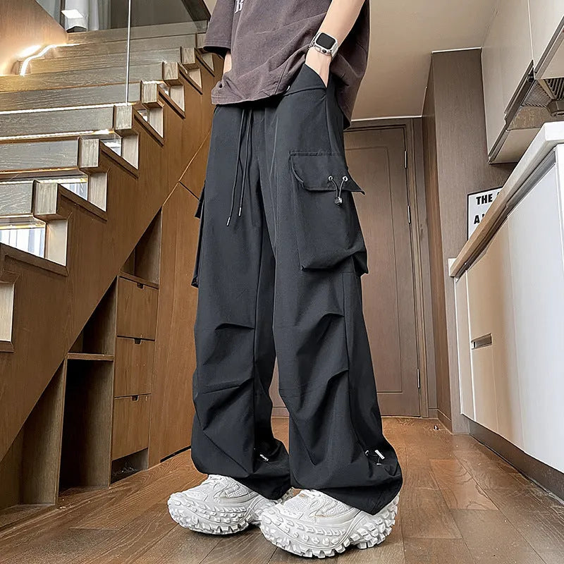 Women's plus size thin waterproof straight-leg trousers in black on a hanger, showing drawstring waist detail.