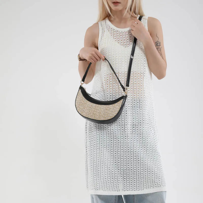 Straw crossbody dumpling bag in a hard suitcase shape with a single shoulder strap.