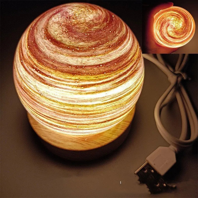 Planet night light with spherical design on base, USB cable connected, showing adjustable three-colour lighting