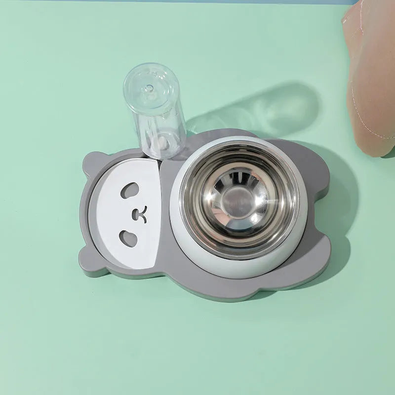 Grey panda-shaped automatic pet water dispenser and tilted food bowl set on a table.