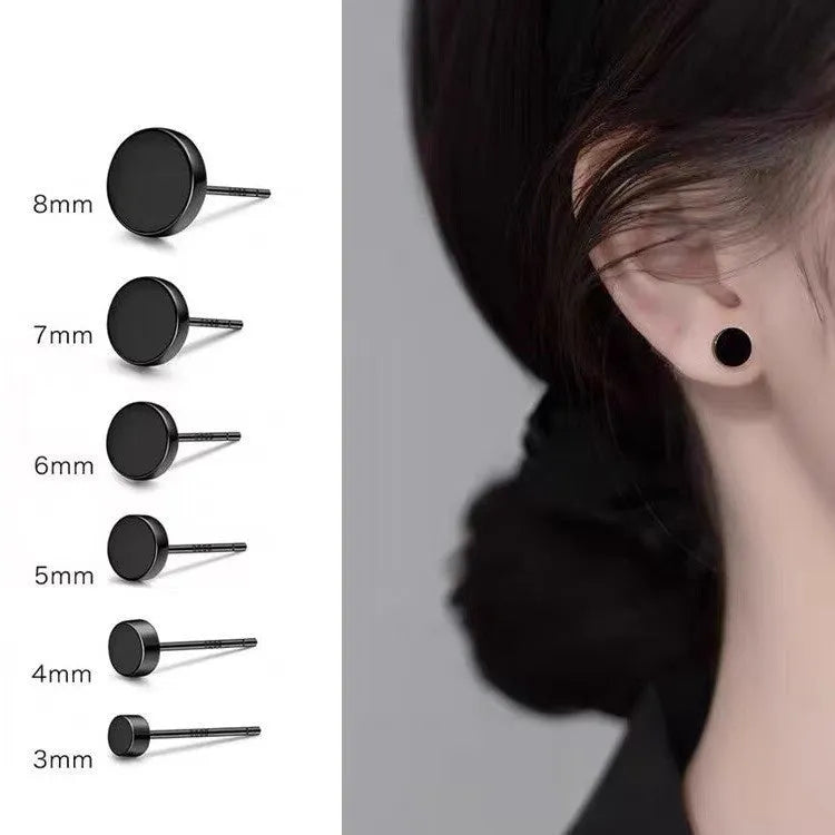 A pair of simple geometric round S999 Sterling Silver flat bone stud earrings in silver and black, showing size variation.