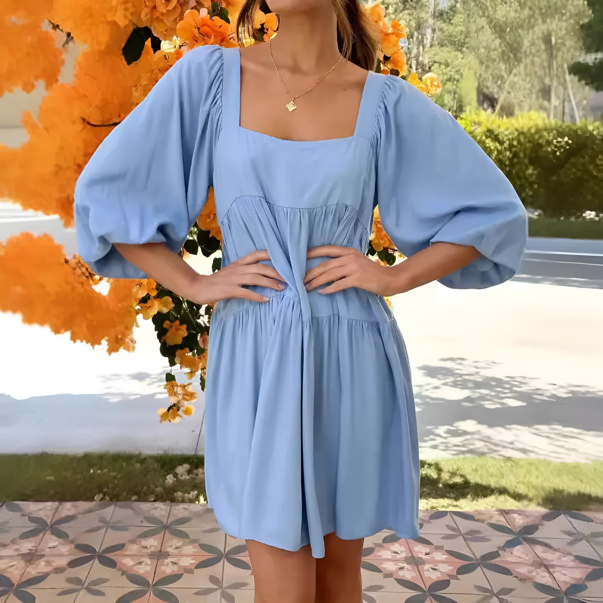 Light blue children's backless dress with puff sleeves, a square collar, and an A-line skirt on a hanger.