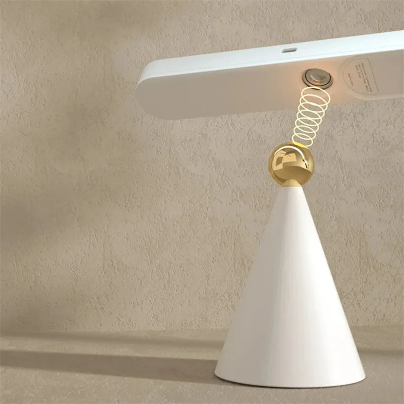 White geometric table lamp with touch switch and USB cable on a wooden desk.