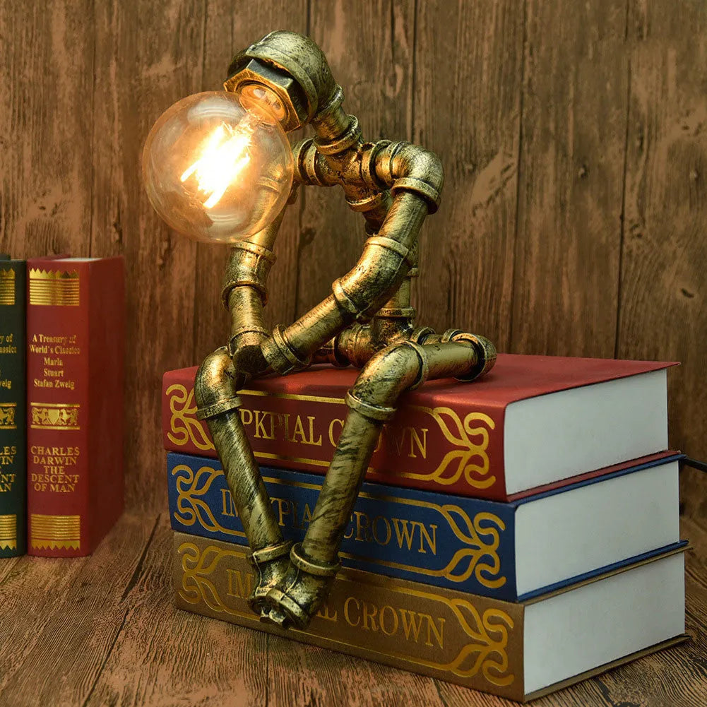 Green bronze vintage industrial iron pipe desk lamp on a wooden table.