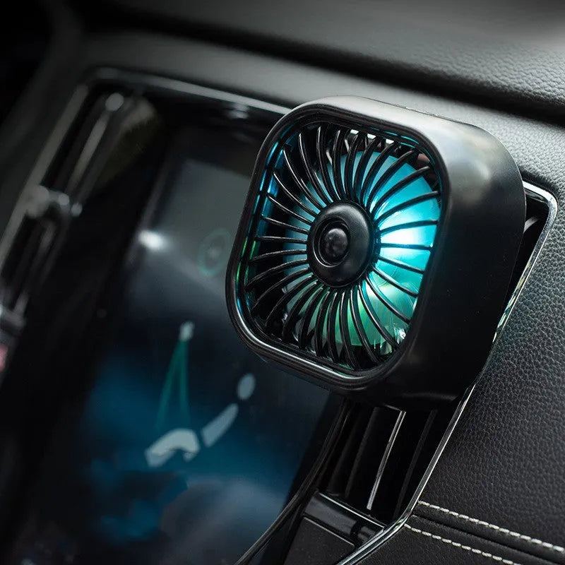 Small black USB fan with keyboard controls for three speed settings on car dashboard