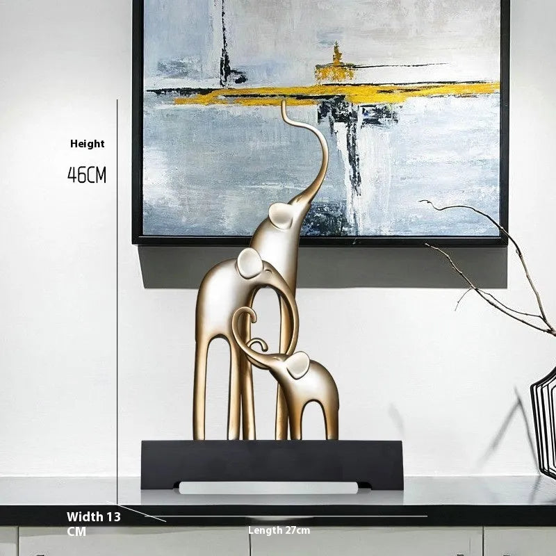 Detailed resin elephant figurine ornament in metallic gold finish on a wooden shelf.