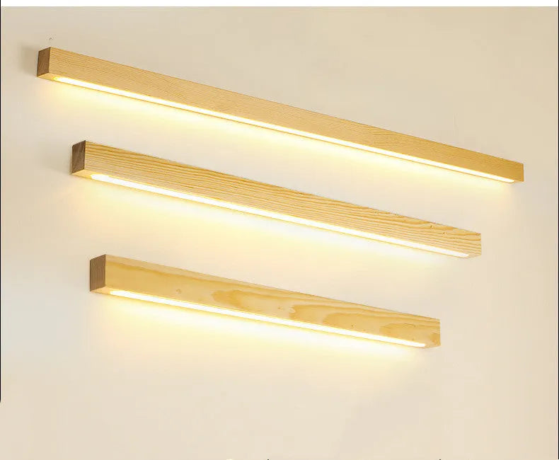 Walnut colour wood and acrylic wall lamp strip with LED lighting in a minimalist design on a wall.
