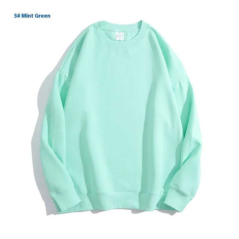 A loose-fitting, off-shoulder cotton sweater in a solid colour with long sleeves and a round neck.