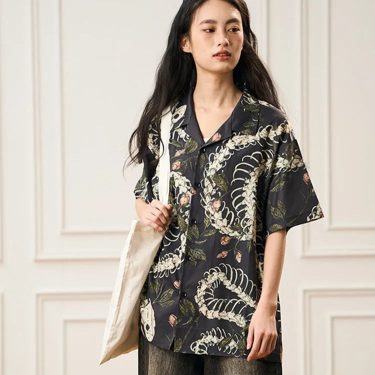 Short sleeve loose-fit shirt with a Cuban collar and a printed snake bone floral pattern.