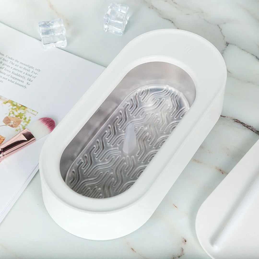 White portable ultrasonic cleaning machine with a stainless steel tank for jewellery and glasses.