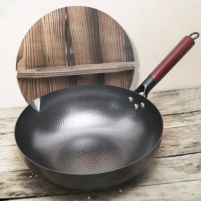 Traditional handmade iron wok pan with wooden handle and induction-compatible base