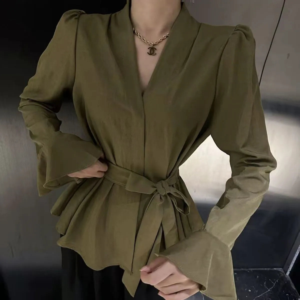 Women's black French-style shirt with irregular collar, long bell sleeves, and a front tie detail.