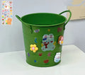 Round metal pen holder in a choice of colours including pink, green, red, white and yellow on a desk.