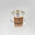 Geometric copper bracelet with irregular coil pattern forming silver-gold wide-faced ring design