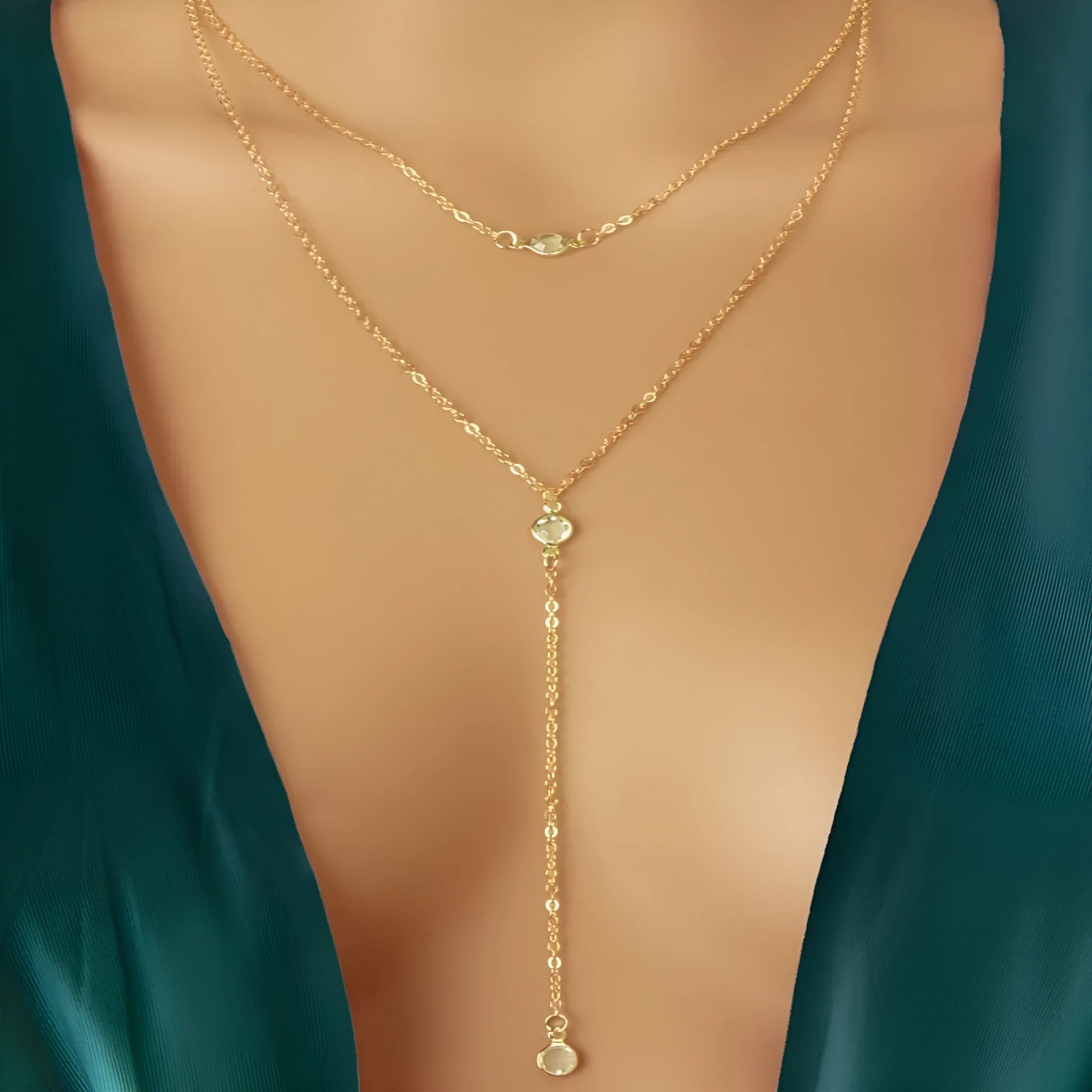 Female gold alloy O-ring chain necklace with geometric pendant on a light background