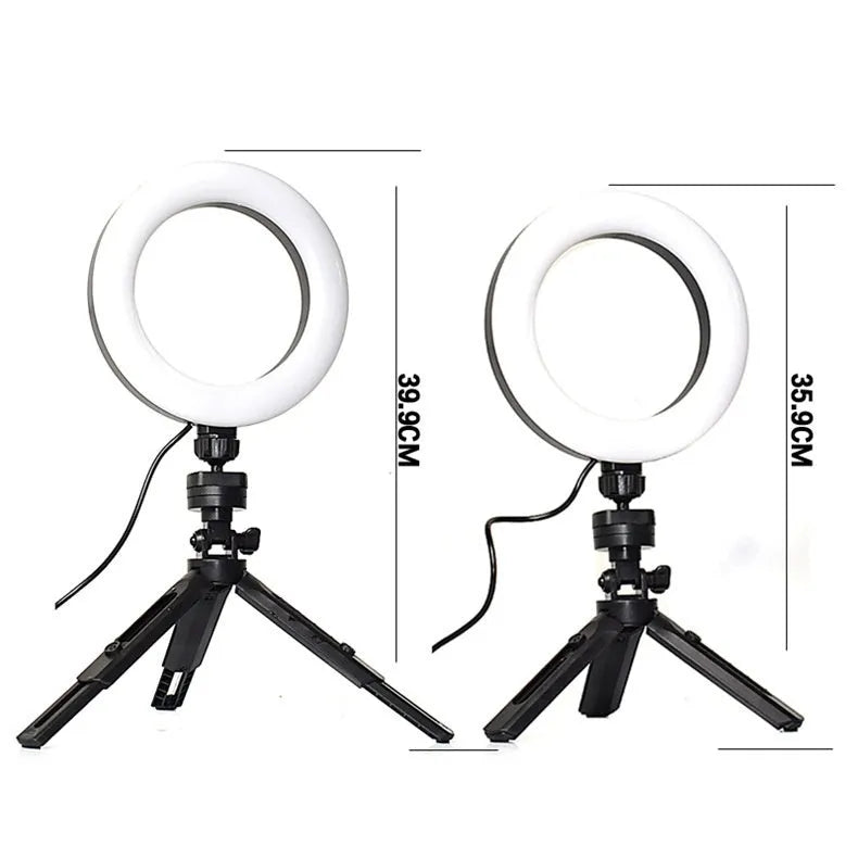Black desktop tripod with adjustable fill light attached, holding a smartphone for streaming or video calls.