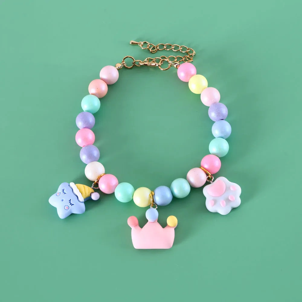 Colourful macaron charm pet collar and matching bracelet set in resin on a white background.