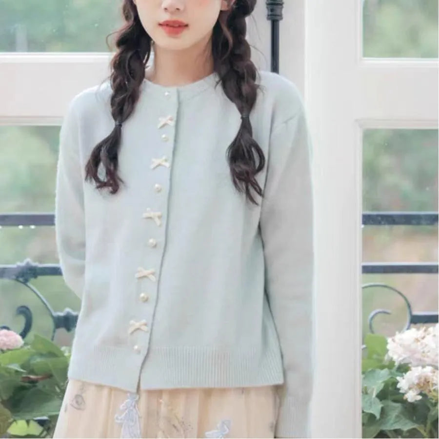 Women's solid colour cardigan sweater with bow and pearl button design in medium thickness fabric