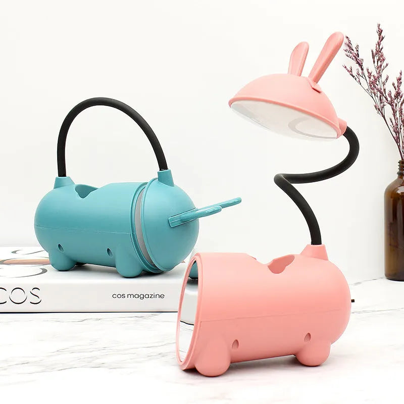 Cartoon-style USB desk lamp with integrated pen holder in green, blue, or pink colour