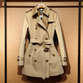 Khaki double-breasted women's trench coat with long flight sleeves, shown on a hanger.