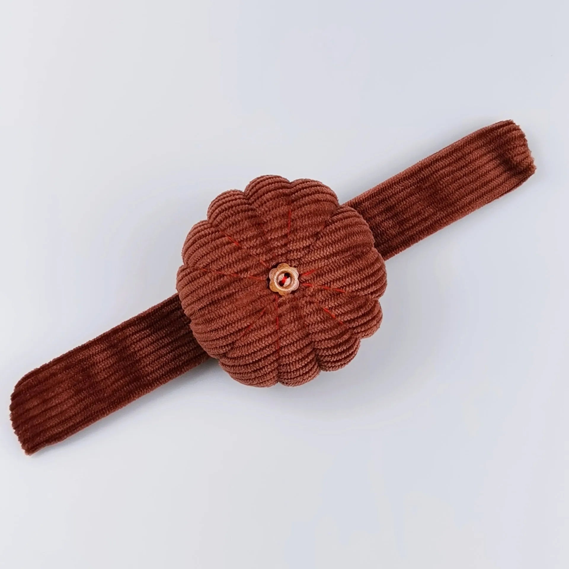Ring pincushion sewing tool with vertical cutting slot in caramel colour showing fabric cushion and metal ring base