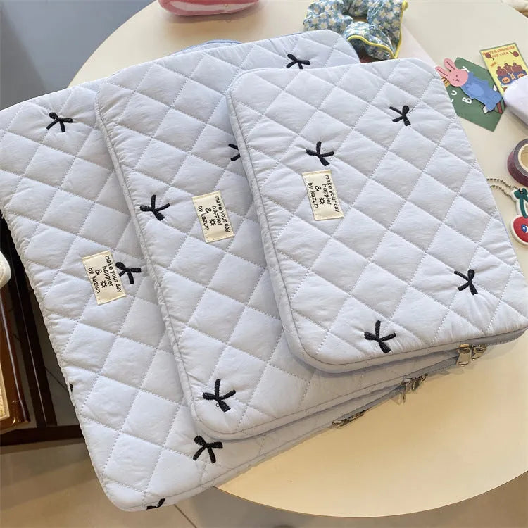 Nylon laptop storage bag with an embroidered rhombus bow in light pink colour.