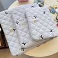 Nylon laptop storage bag with an embroidered rhombus bow in light pink colour.