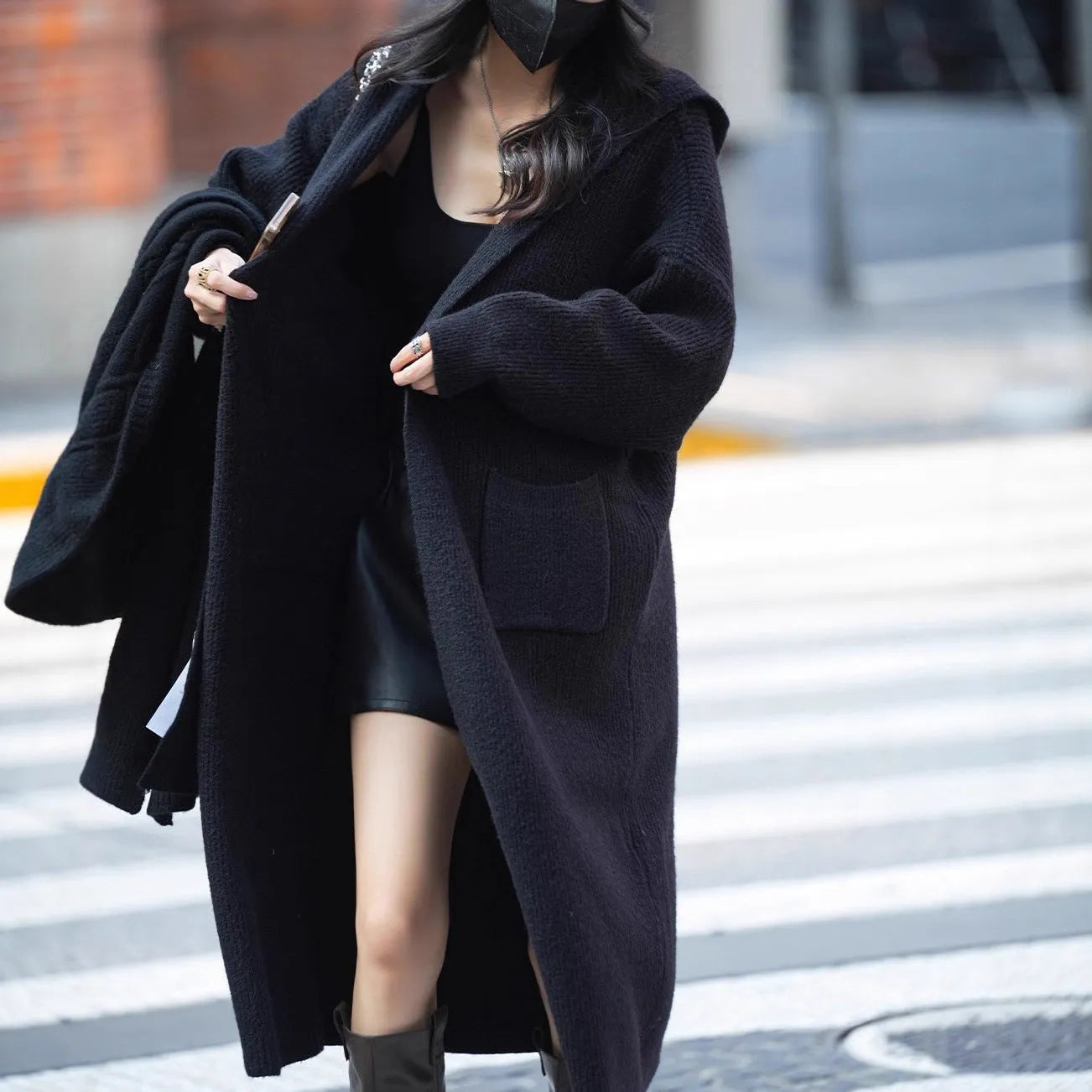 Long grey knitted hooded cardigan trench coat on a hanger, showing loose fit and long sleeves.