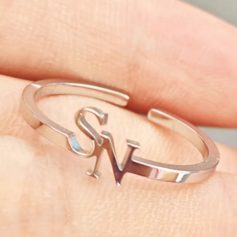 Customised two-letter open ring in stainless steel silver and gold electroplated finish on a white background