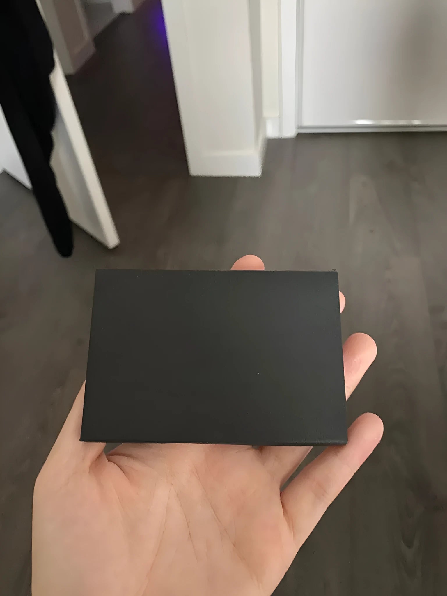 Plain black mailing envelope measuring 9 cm by 6 cm, shown flat with a flap