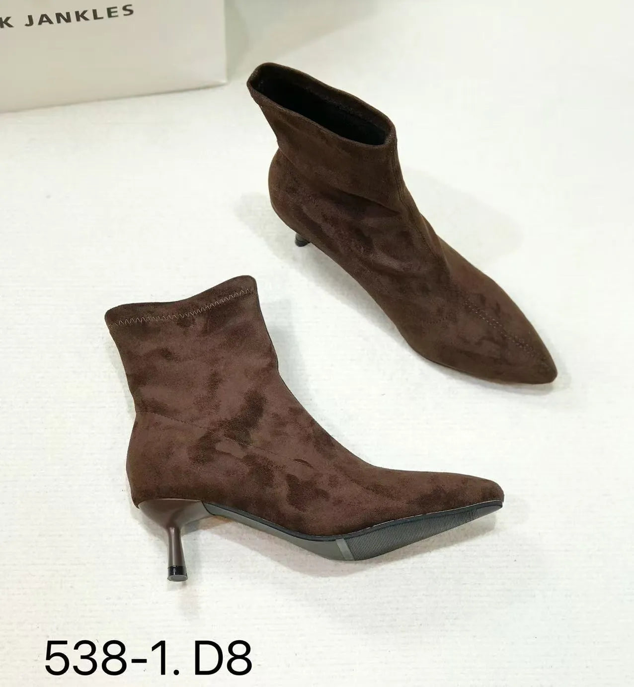 Black pointed toe women's ankle boots with a high stiletto heel on a rubber sole.