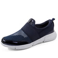 Low-cut blue women's casual sneakers with mesh upper on a hard floor surface.