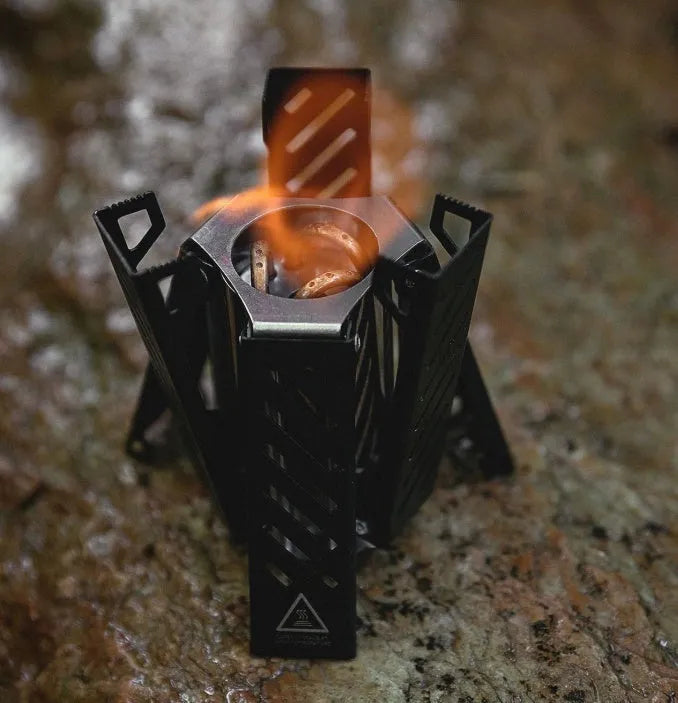 Mini hexagon alcohol stove in black showing foldable design and alloy construction for camping