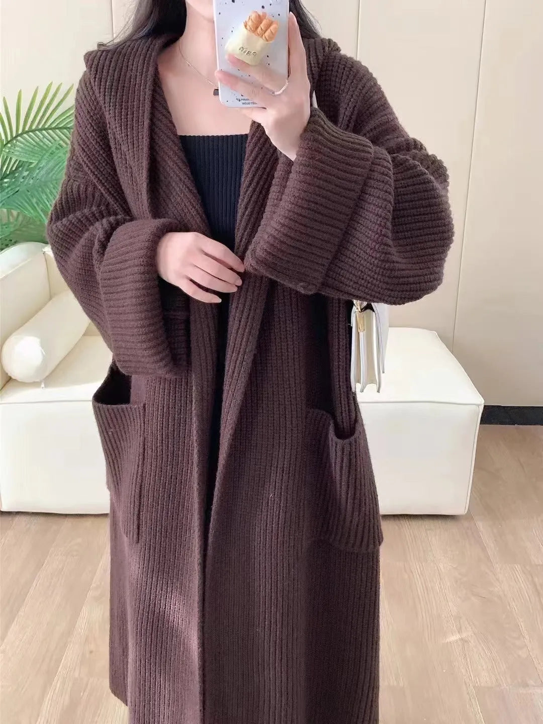 Women's loose grey hooded cardigan coat with raglan sleeves on a hanger