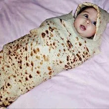 Round coral fleece flannel blanket rolled in a burrito style, showing soft texture and printed design.
