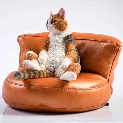 Small lazy cat car ornament and sofa, 7.5cm tall resin model on a car dashboard.