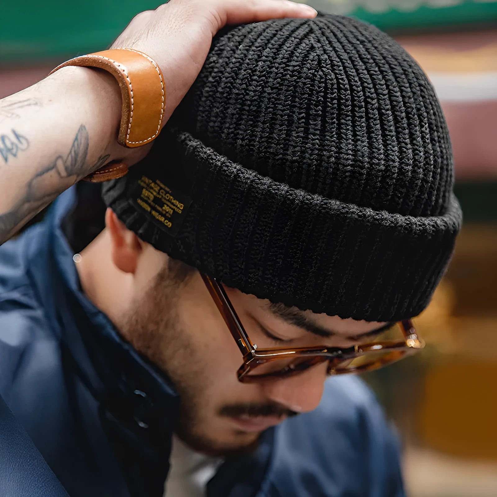 Vintage knitted melon skin warm beanie in black with patch detail on a plain background