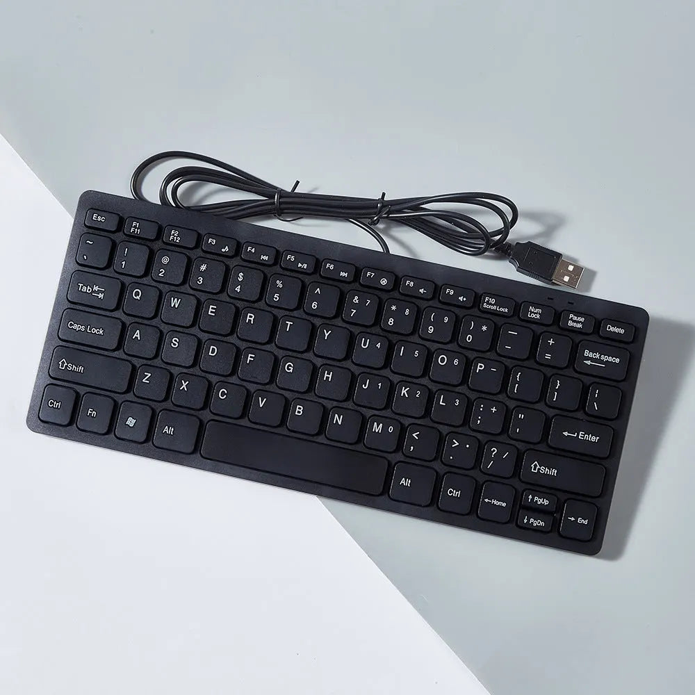 Compact USB wired mini keyboard in black, white, pink, or blue on a desk.