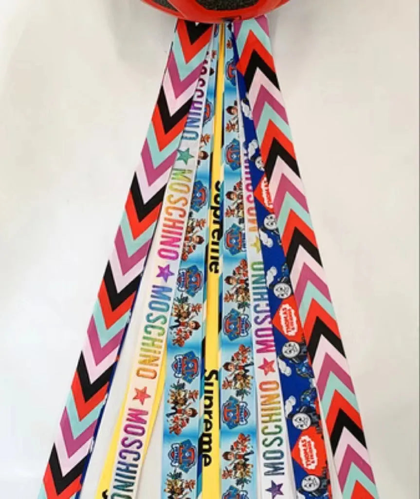 Colourful decorative ribbon streamers attached to a children safety helmet for skating or skiing