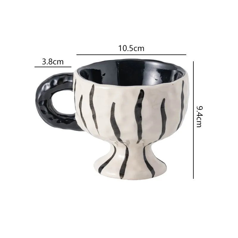 Hand-pinched irregular shaped ceramic mug in a solid colour on a table.