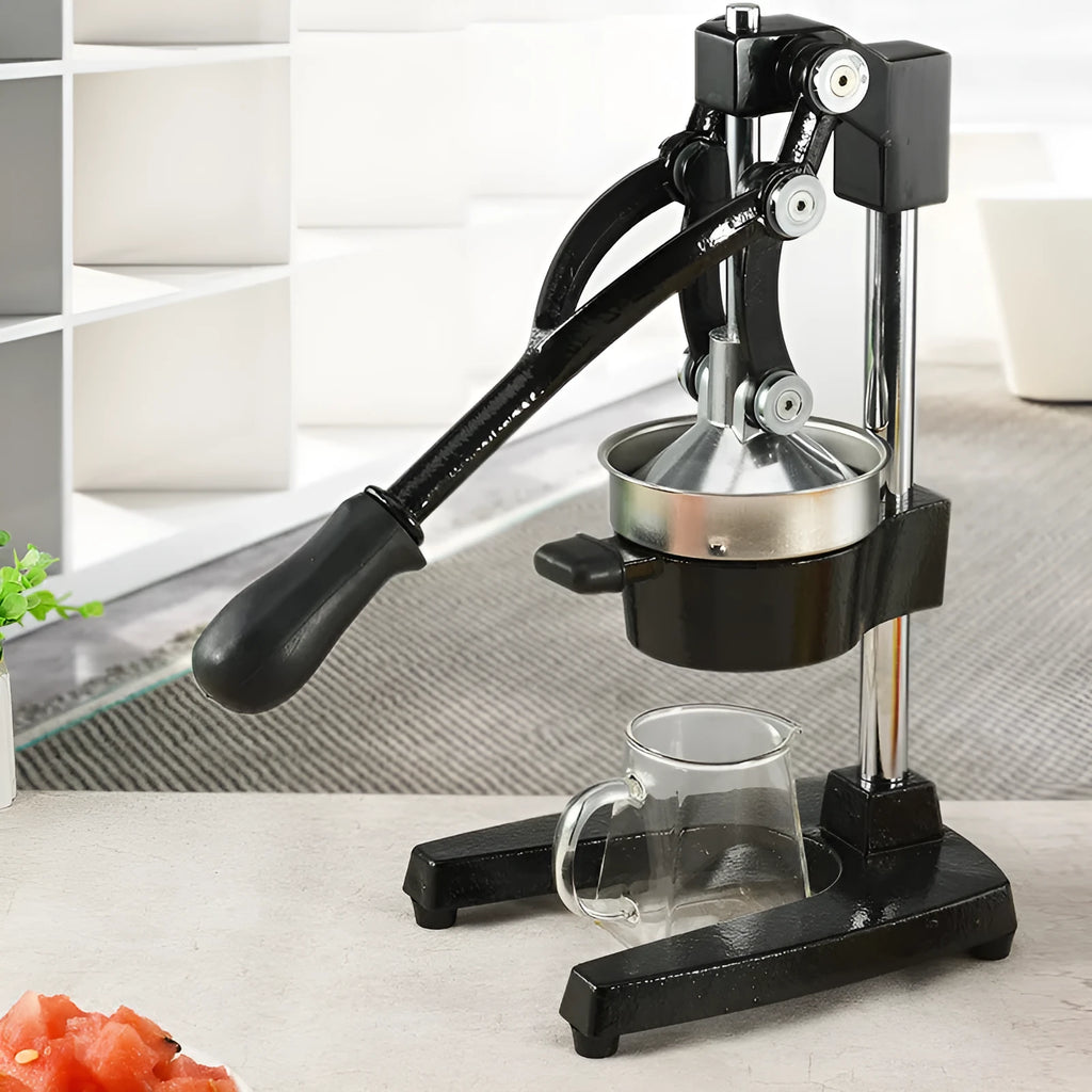 Tall black cast iron manual citrus juicer with stainless steel strainer on a kitchen counter.
